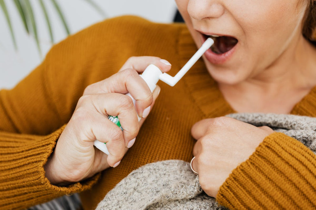Woman using an oral throat spray